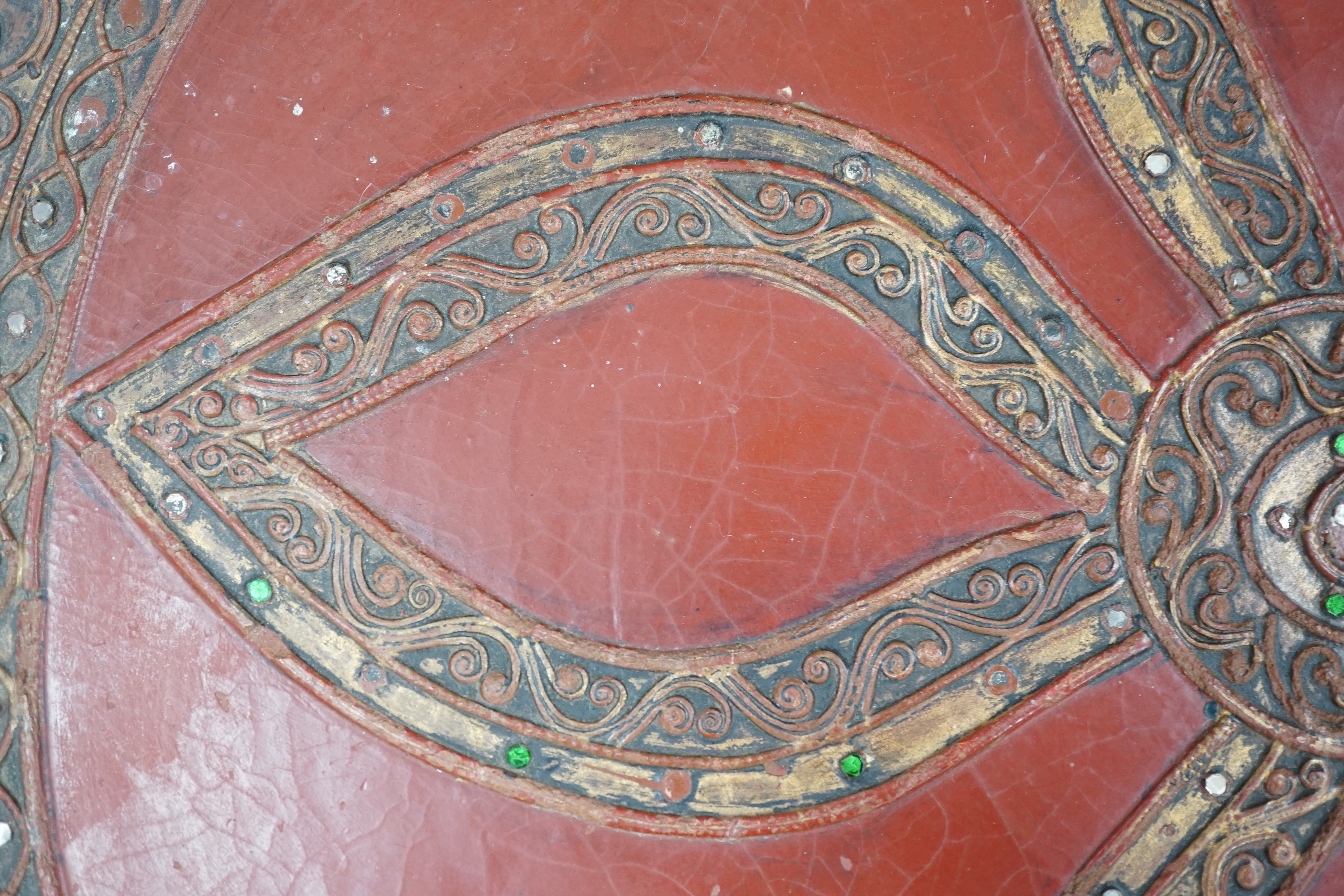 A South East Asian composition red lacquered table inset mirrored sequins, 44cm high x 51cm in diameter